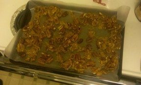 Candied pecans cooling on the sheet, absorbing their own deliciousness.
