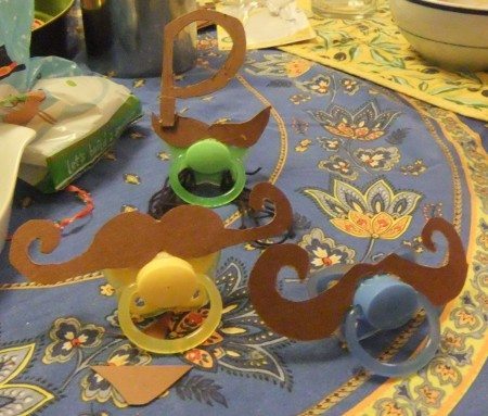 Our mustache pacifiers on the table, awaiting cute babies to model them.